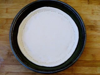 13、八寸披萨饼饼胚,用叉子把饼边缘扎孔固定。