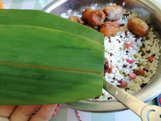 5、杂豆蜜枣粽,粽叶需要刷子洗几次，开水烫一下，洗粽叶的过程我就没拍图了，估计大家都懂的，然后取一大一小两片粽叶，大的在下面，小的在上面，剪去头。