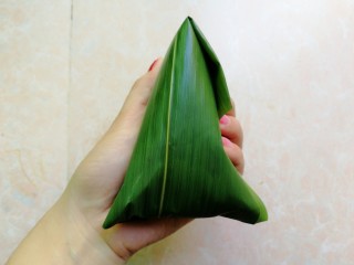 10、杂豆蜜枣粽,然后再把粽叶折回来收口，粽叶太长的话，可以剪掉一些