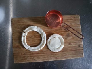 3、迷你培根鸡蛋酥饼,取一个软化好的蛋挞皮，取一个量勺（大小跟纸杯大小相同），按压取片