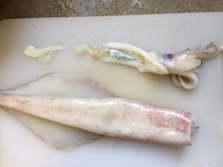1、韩式辣烤鱿鱼,拉住鱿鱼头，把内脏一起拉扯出来。