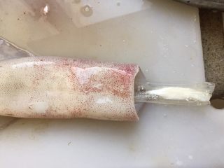 5、韩式辣烤鱿鱼,再用勺子挖干净鱿鱼筒内的所有内脏，抽出鱿鱼的软骨。