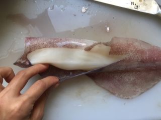 6、韩式辣烤鱿鱼,撕掉鱿鱼筒表面的紫色表皮，鱿鱼须上的紫色表皮也尽量撕掉。