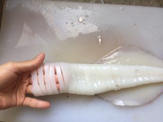 9、韩式辣烤鱿鱼,把鱿鱼筒的一面，切1cm左右的宽度，但不要切到另一面。鱿鱼尾用刀划十字花，不要切断。鱿鱼须轻划几刀，不要切断。