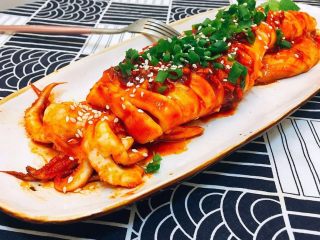 12、韩式辣烤鱿鱼,平底锅烧热，抹一层油，放入鱿鱼，两面先各煎一分钟，接着边刷酱汁边煎，一共煎4分钟。装盘，抹上剩余的酱汁。撒上葱花，芝麻，淋一点芝麻油，完成。