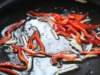 8、韭花炒肉丝,另起锅加入适量的色拉油，放入大蒜丝、红椒丝翻炒出香味