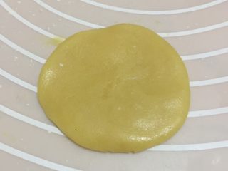 6、广式豆沙月饼,取一个饼皮按扁。