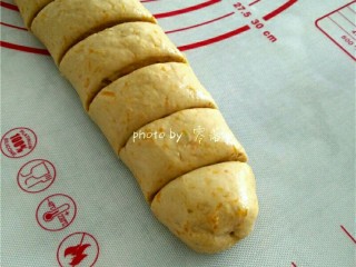 6、南瓜豆沙丸子,面团一分为二，将面团擀成长条形，用刮刀切开；