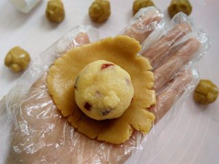 12、椰蓉蔓越莓月饼, 戴上一次性手套，取其中一个面团用2个掌心的摩擦力按扁，放上椰蓉蔓越莓馅