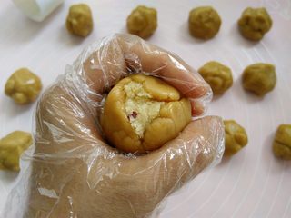 13、椰蓉蔓越莓月饼,手心合起来，用虎口把面团慢慢收圆，皮厚的地方可以推到皮薄的地方，尽量推的均匀一点