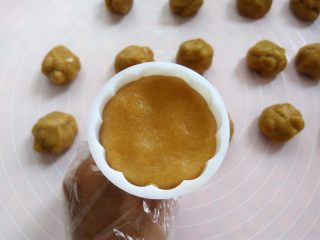 14、椰蓉蔓越莓月饼,把月饼球放入50克模具里，可以按压一下模具边缘，压出来的花纹更立体