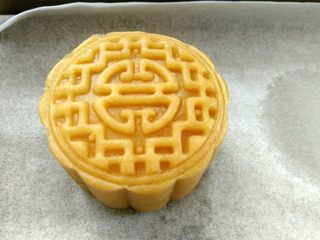 15、椰蓉蔓越莓月饼,月饼模具倒扣在烤盘上，向下按压，轻轻提起模具（我用金盘烤也垫一层油纸，方便清洗）