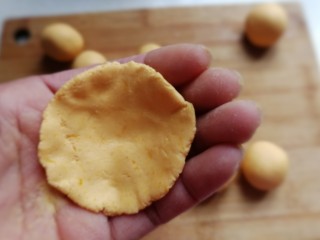7、南瓜豆沙小汤圆,取一个糯米团先用手掌压扁，然后把四周用手捏薄，使其成四周薄中间厚的形状
