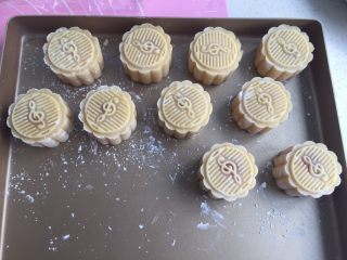 13、莲蓉蛋黄月饼（50克）,放入面团圆球，直接在烤盘上压制成型。烤箱预热上下火175度，放入烤箱中层烤7分钟。