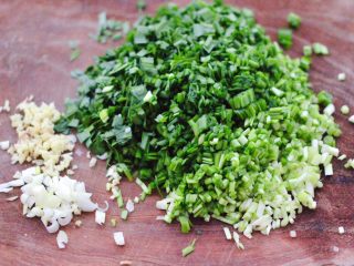 2、韭菜粉条发面包,把洗净的韭菜，用刀切碎，把葱姜切碎。