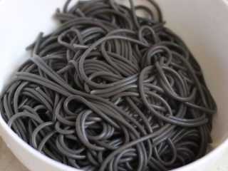 3、海鲜墨鱼汁意大利面,面煮好，捞出，泡冷水备用，用剩下的面汤焯熟虾和鱿鱼圈，并且控干水分