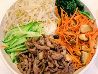 15、韩式拌饭,依次铺上胡萝卜丝、香菇、肉条、青瓜、豆芽、菠菜
