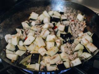 7、肉末茄子,当猪肉变成褐色后,加入茄子,把所有的肉一起翻炒。炒制五分钟。