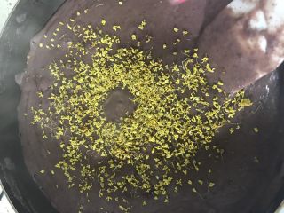 2、豆沙糕,把打好的泥倒入不粘锅里撒上桂花加入黄油跟白砂糖