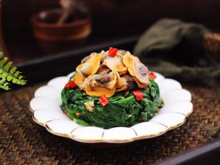 17、蒜蓉菠菜拌毛蛤,把拌好的菠菜放入盘子里,上面码上煮熟的毛蛤就可以了。