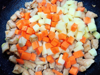 8、咖喱鸡肉土豆,放入土豆块、胡萝卜块，翻炒均匀。