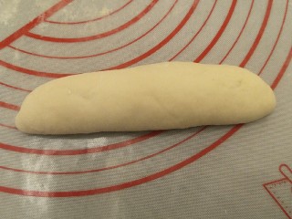 12、蒜香香肠热狗面包,从上往下搓回来。整形成纺锥体,封口朝下。开始第二次发酵到两倍大。