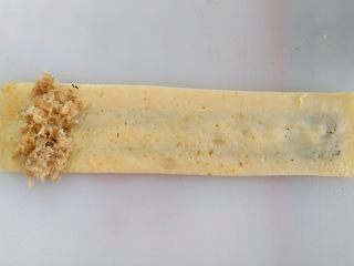 13、紫菜肉松鸡蛋卷,蛋饼翻面，左侧放上肉松，从左向右卷起来