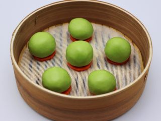 14、清新碧绿的青叶汁黑芝麻豆沙青团,把所有的青团做好后、放到胡萝卜上面