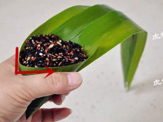 3、经典四角粽子包法详解，长寿米粽子 ,将苇叶按照折痕窝成漏斗状，里面装满馅料，蜜枣花生放在中间，这样煮好的粽子才甜味均匀。