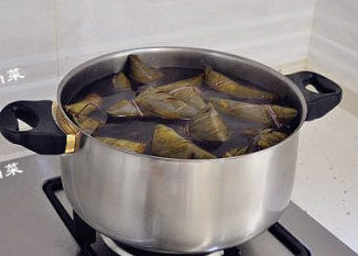 10、经典四角粽子包法详解，长寿米粽子 ,焖煮4个小时左右，中间加一次开水，煮至香味浓郁，苇叶变色，黑糯米软糯，汤汁也变得浓稠了即可。