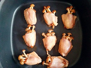 9、采鸡翅的小蘑菇(无油版),不沾平底锅预热一下,将鸡翅外侧朝下放进锅中,鸡皮受热会出油,锅中不用放油了哈,少油更健康。