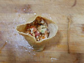 11、卡通小熊豆腐糯米包便当,打开豆腐包,填入糯米馅,填到7分满就可以了。用手压实一下。