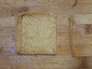 10、卡通小熊豆腐糯米包便当,取一个日式豆腐包。将其中一个边缘切开。