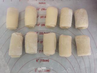 15、小龙虾月饼,再取一个卷换个方向,压扁擀长卷起,用保鲜膜盖好松弛15分钟