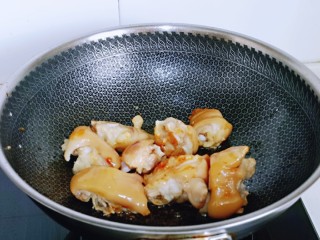 4、啤酒炖猪蹄,待冰糖褐色时下入焯过水的猪蹄,炒糖色,使每个猪蹄均匀挂上糖色。