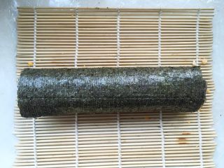 5、咸蛋黄红虾寿司,用竹帘将寿司卷起，卷的时候一定要卷紧