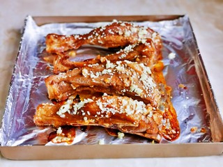 12、蒜香烤排骨,时间到后取出烤盘，撒上蒜末，白芝麻，入烤箱190度再烤10分钟。