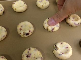 15、蔓越莓玛格丽特,用大拇指在每个面团中间按扁,至边缘裂开。