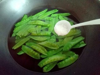 10、#时令蔬菜#荷塘月色小炒,荷兰豆焯水: 锅中加入水，大火烧开后倒入荷兰豆，加入一勺盐，(这种焯水方法可以保持绿色蔬菜的翠绿色。)50秒捞出立即过冷水。