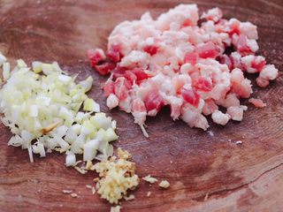 4、辣椒叶酱肉包,把猪肉洗净后,用刀把猪肉切成小丁,葱姜切碎。