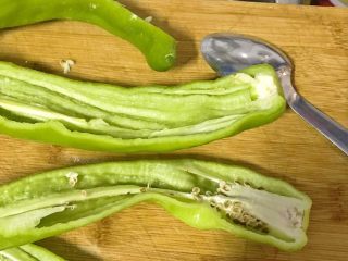 5、榛蘑炒辣椒,青辣椒中间刨开，用汤匙把中间的种子剥去。