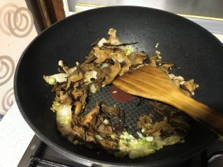 12、榛蘑炒辣椒,再倒入蘑菇，淋一汤匙酱青，翻炒。