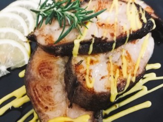 11、柠香煎鳕鱼,摆盘，另外一根迷迭香摆在上面装饰鳕鱼 上面再淋些柠檬芒果汁即可。