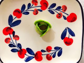 4、吃掉一朵花~三文鱼味道的牛油果刺身,找一个你喜欢的盘子,把切好的牛油果如图所示,一片围着一片竖着摆起来