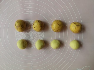 6、表情包双味南瓜饼,先制作蔓越莓面团包原味豆沙的南瓜饼，将蔓越莓面团分成30g一个的小剂子搓圆备用，再取原味绿豆沙20g一个搓圆备用
