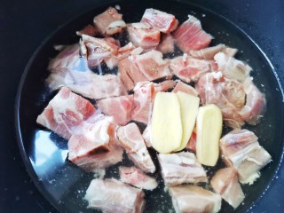 5、胡萝卜炖排骨,锅中放入排骨,加入没过食材的凉水,加三片姜,