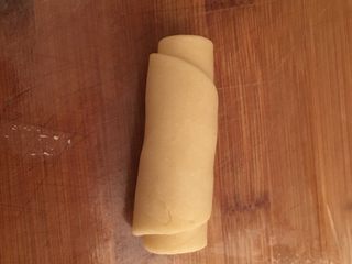 6、酥皮鲜肉月饼,再把它卷起来，我在菜板上蒙了一层保鲜膜防粘