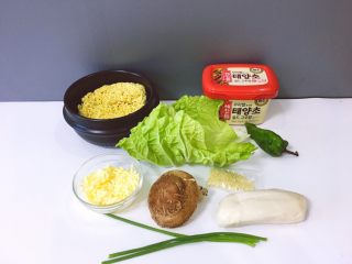 1、芝士年糕拉面 泡面花样吃,将泡面，白菜，香菇，年糕，辣椒，韩式辣酱，白芝麻，香葱，芝士碎材料准备好