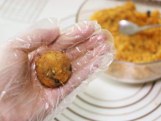 8、蛋黄肉松麻薯球,将馅料平均分成12份，每份约26g（咸蛋黄大小不同，馅料多少会有差异），两手来回交替将馅料攥紧搓圆（尽量攥紧实，以免包馅的时候容易松散）