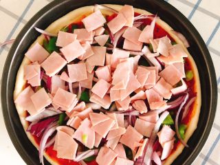 13、芝士培根披萨,将培根铺到面饼上。